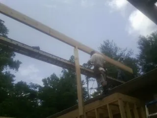 Carpenter setting a ridge beam over a new addition frame — Ice Dam Removal by Roofing Brothers in Frederick