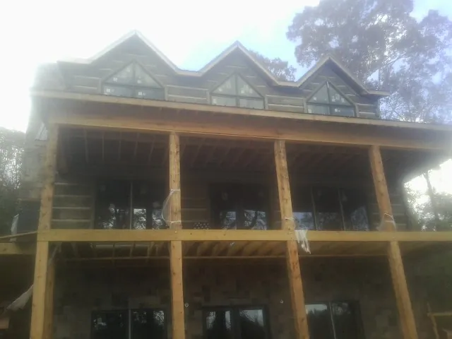 Dormers and porch framing on a large log home under construction — Roof Coating work by our crew in Frederick